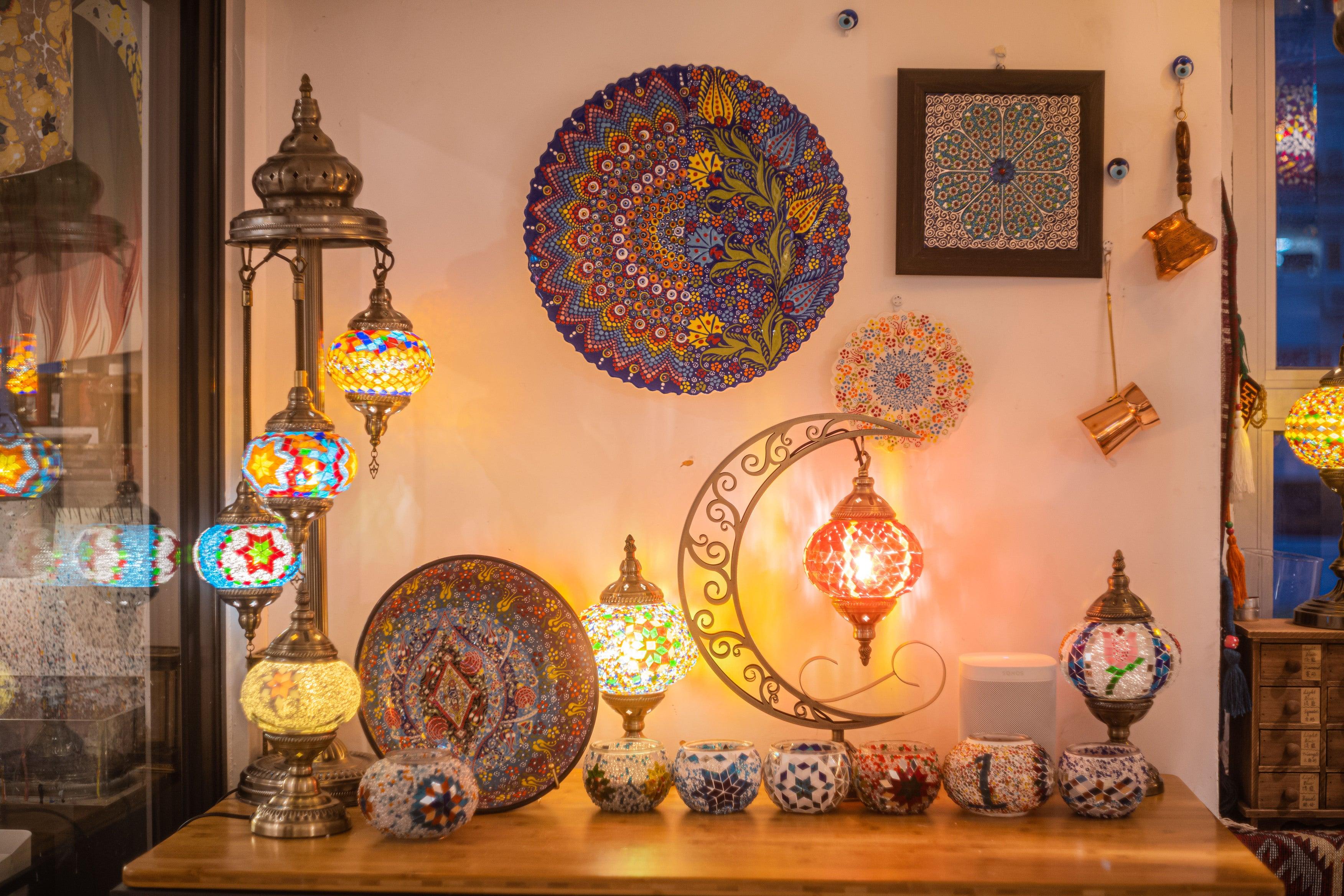 Colorful mosaic stained glass lamps and decorative plates with intricate patterns on a wooden table
