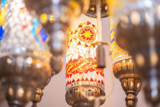Close-up of colorful mosaic glass lantern with red and yellow geometric patterns and ornate metal fixtures