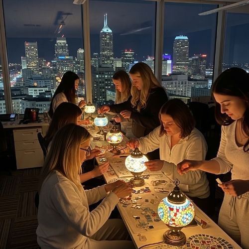 Group of women crafting with mosaic tiles at night in Indianapolis high-rise with city skyline view