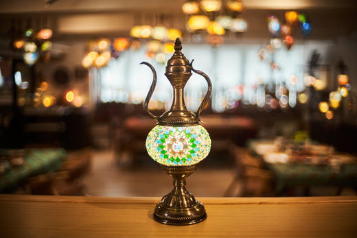 Antique brass and mosaic glass decorative lamp on wooden surface with warm restaurant background
