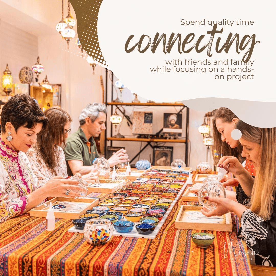 Group of people engaged in mosaic art project at vibrant studio with colorful tiles and warm lighting