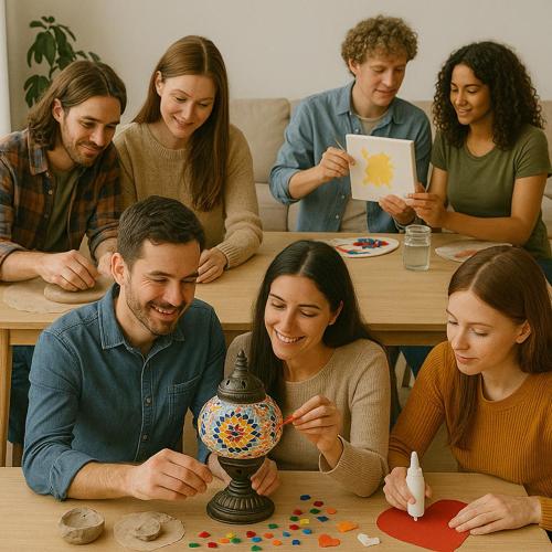 Group of six young adults enjoying couples crafts, painting and decorating a mosaic lamp indoors