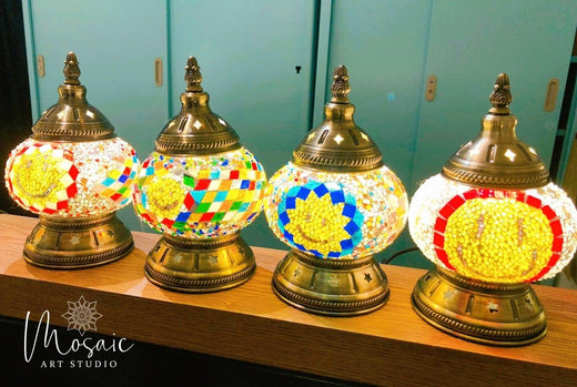 Four colorful Turkish mosaic lamps with intricate glass designs on brass bases displayed indoors