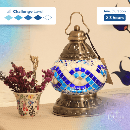 Turkish mosaic lamp with blue and white Aegean wave motif next to floral vase with dried flowers