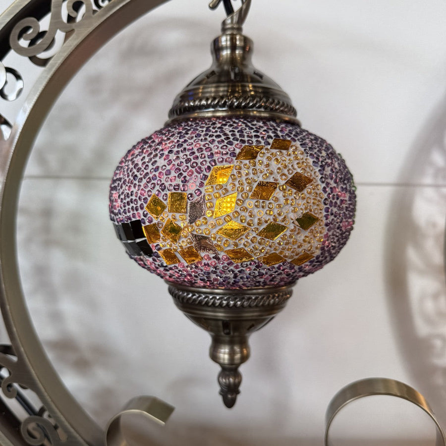 Amber and lilac mosaic globe lamp hanging inside a crescent moon lamp frame