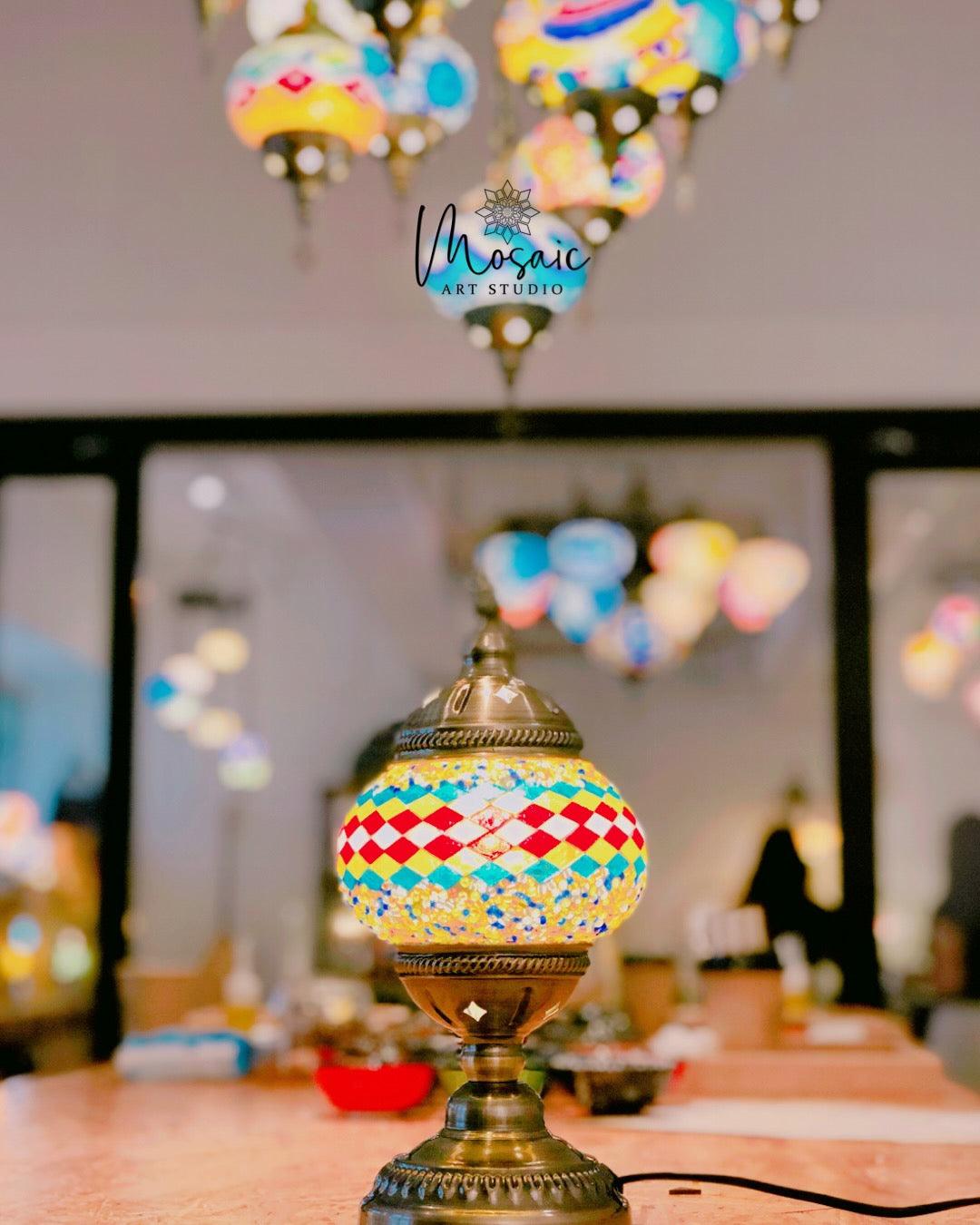 Turkish mosaic lamp with colorful geometric patterns on a table in art studio