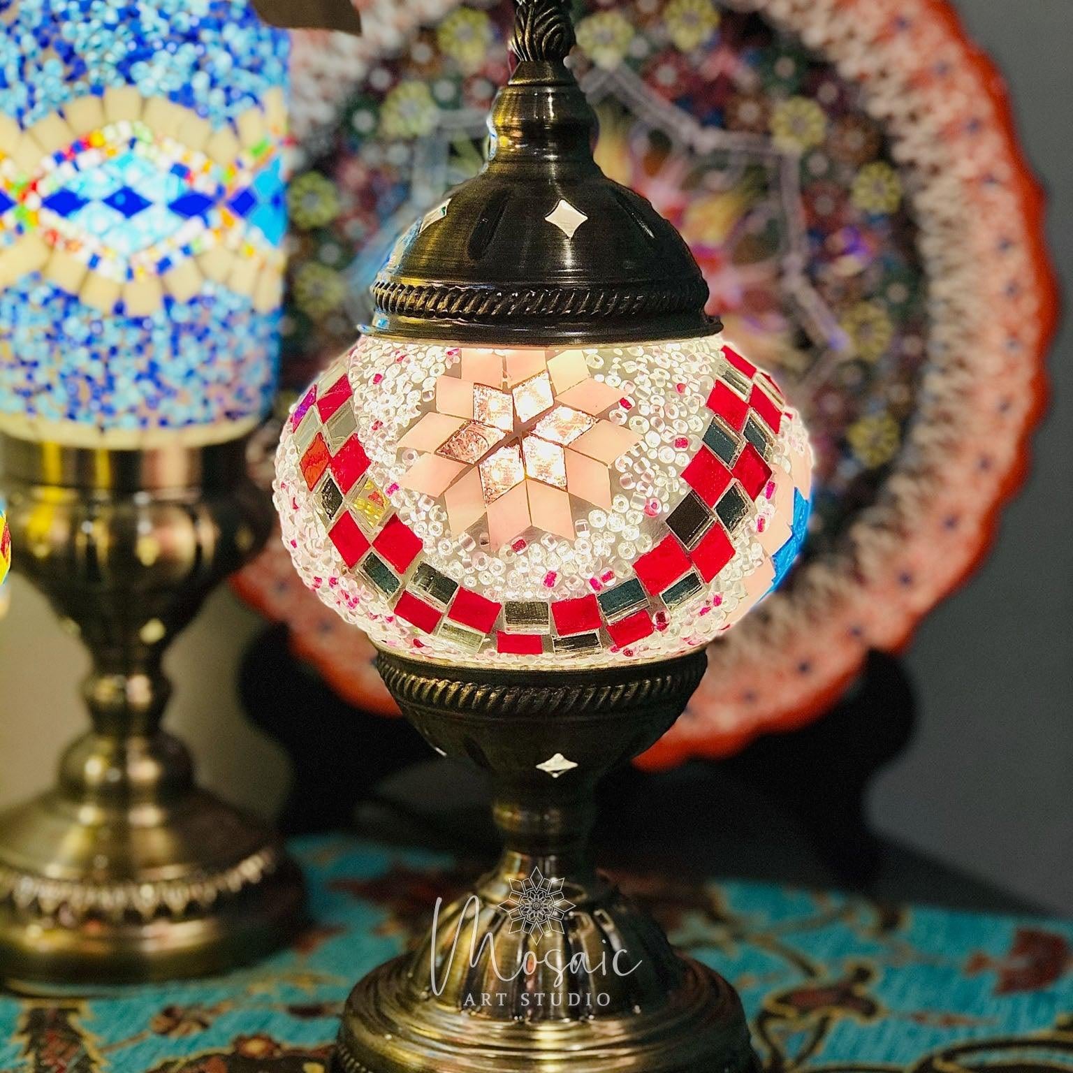 Turkish mosaic table lamp with star pattern in red and white tiles on brass base, colorful mosaic backdrop