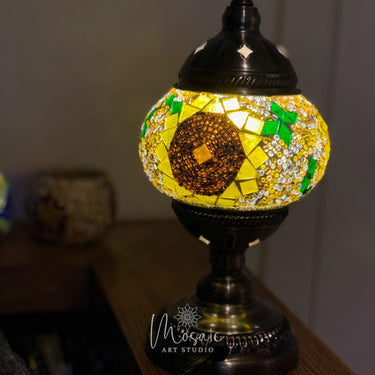 Turkish mosaic table lamp with colorful floral design, illuminated on wooden surface