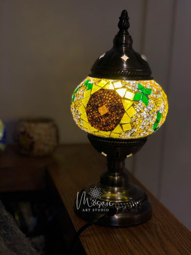 Turkish mosaic table lamp with colorful floral design, illuminated on wooden surface