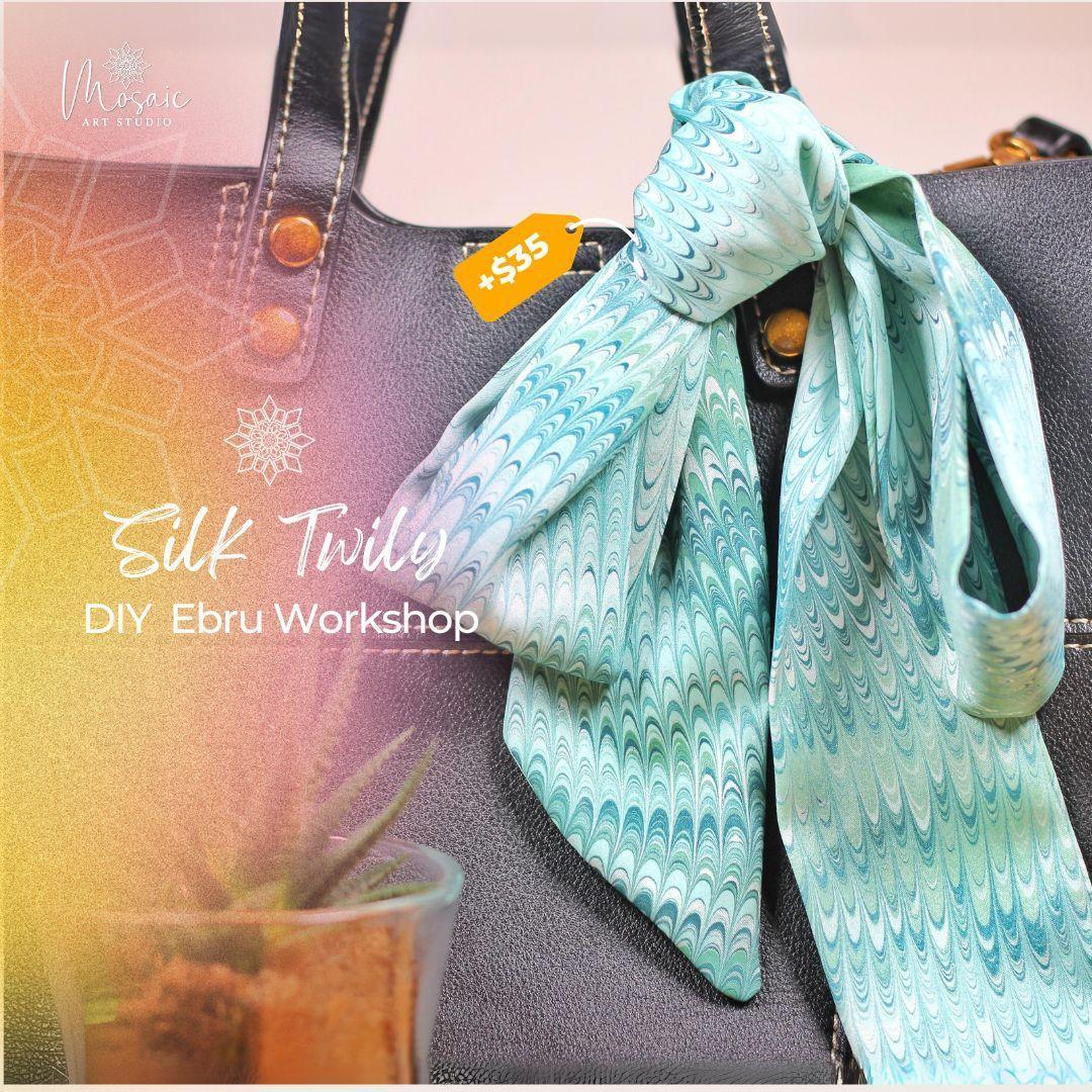 Light blue silk twilly scarf with wave pattern tied to black leather bag handle, DIY Ebru workshop promo