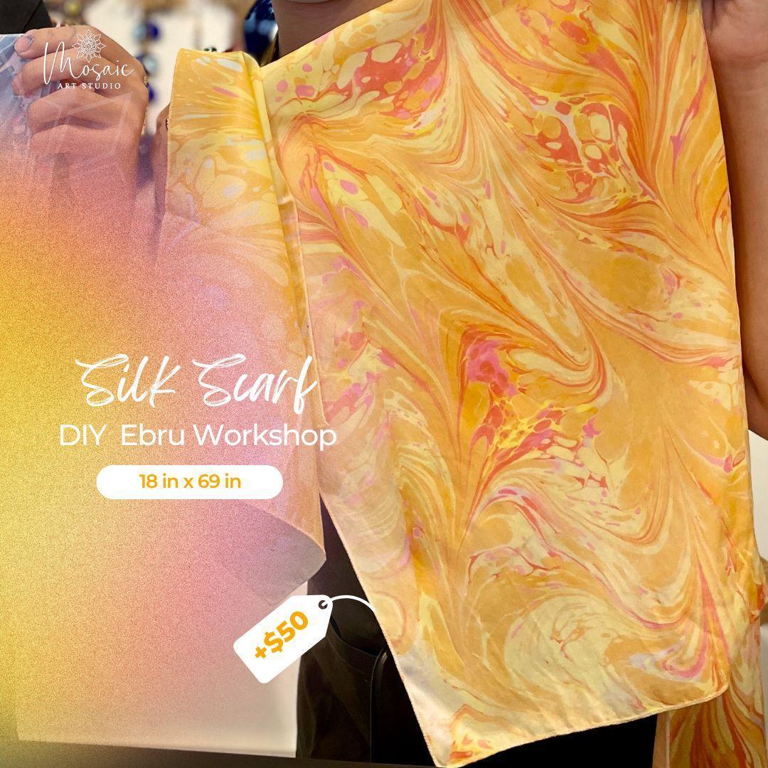 Hand holding colorful silk scarf with orange, yellow, and pink marbled design, DIY Ebru art style