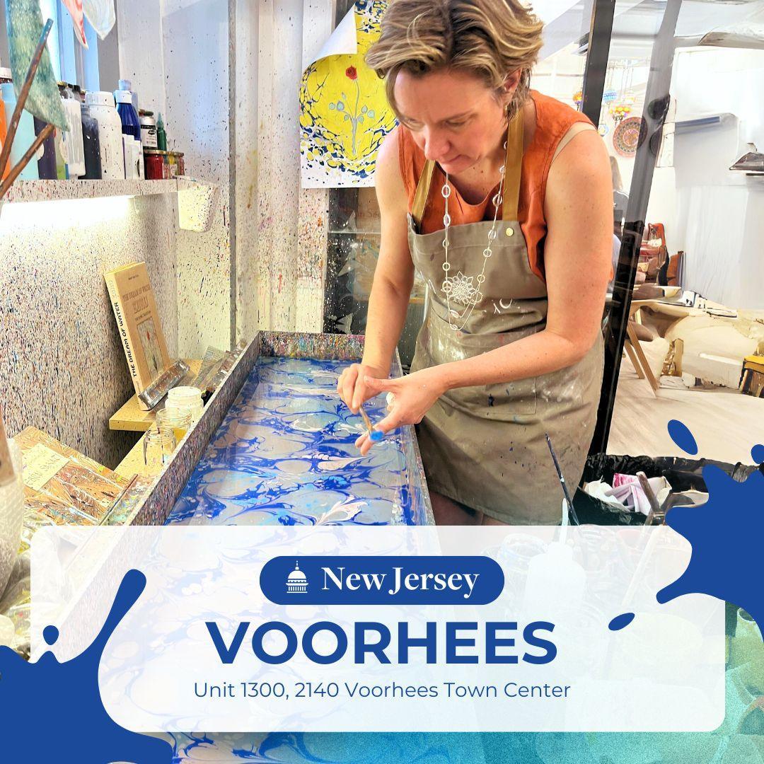 Woman creating blue ebru art using water marbling technique in art studio at Voorhees, New Jersey