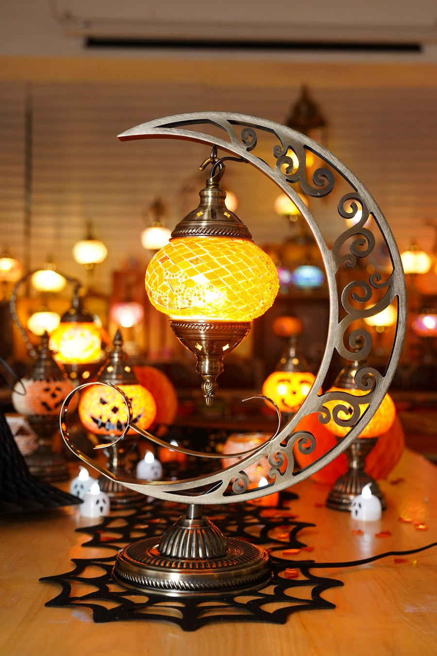 Handmade Halloween mosaic lamp glowing among candles