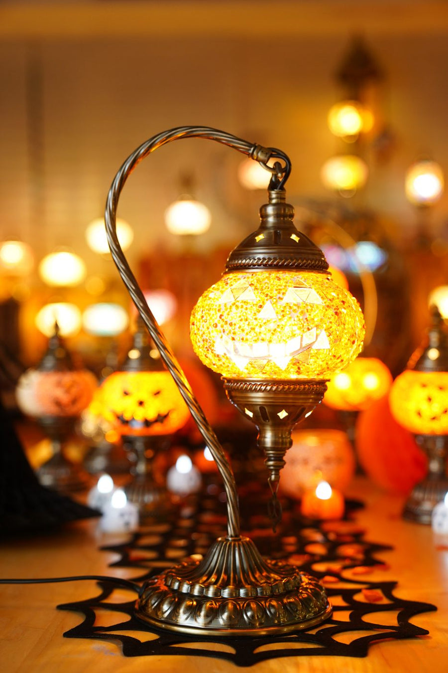 Handmade Halloween mosaic lamp glowing among candles