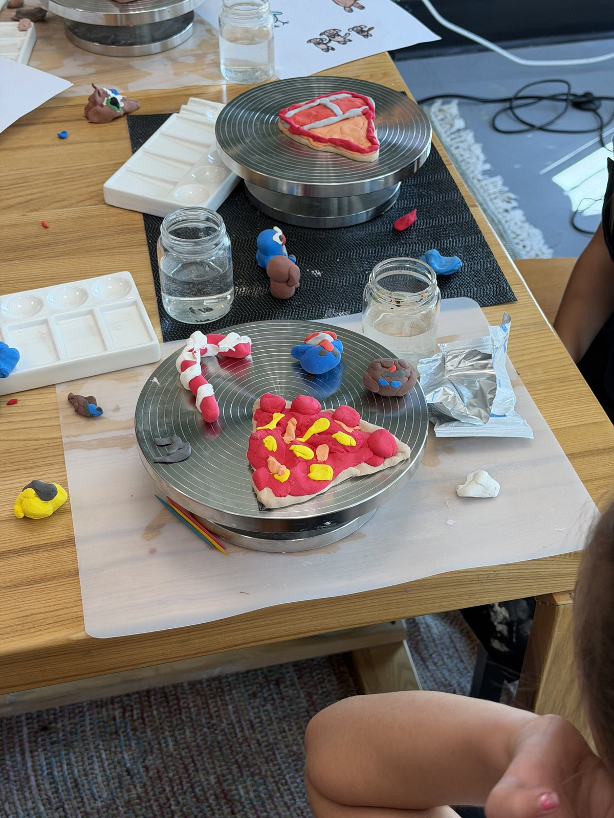 Finished hand-sculpted clay pieces drying on a studio worktable
