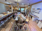 Students working on art projects together at a long studio table in a Mosaic Art Studio class