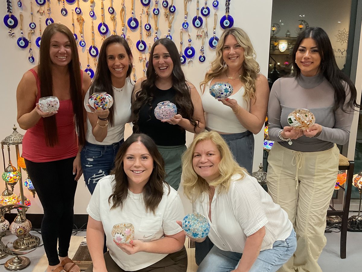 Friends showing their finished mosaic lamps at a girls' night in Voorhees, NJ