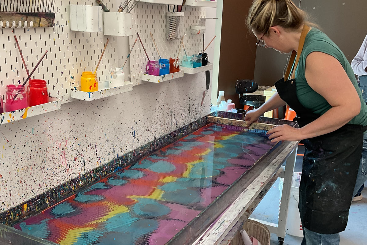 A guest creating a water marbling (ebru) design on her own at Mosaic Art Studio Voorhees
