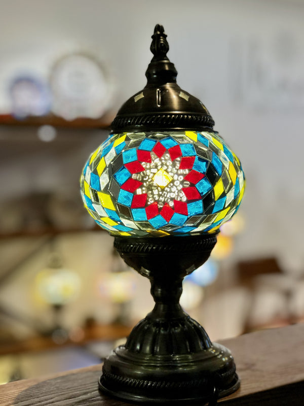 Red medallion ringed in teal and gold. Handmade with love at a Mosaic Art Studio workshop.
