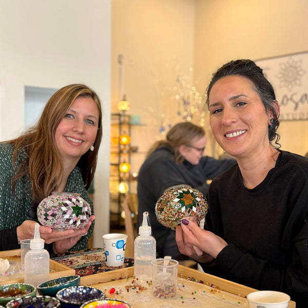 Two best friends smiling with their mosaic lamp globes
