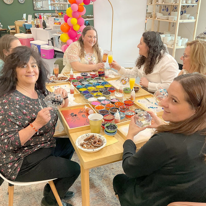Party guests making mosaic lamps at a decorated table