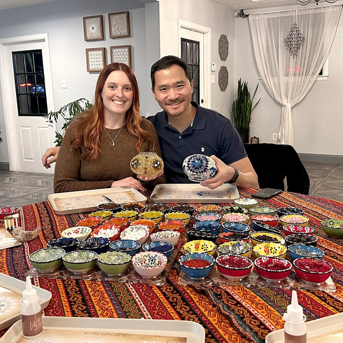 Couple smiling at a mosaic lamp workshop table
