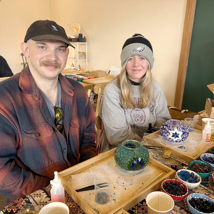 Young couple making Turkish mosaic lamps side by side