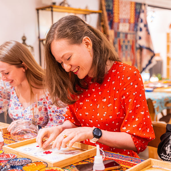Two guests planning their mosaic patterns on design paper at a Turkish mosaic lamp workshop