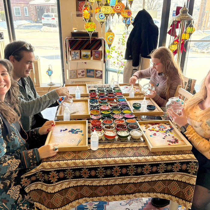 Friends smiling at a Turkish mosaic lamp workshop table