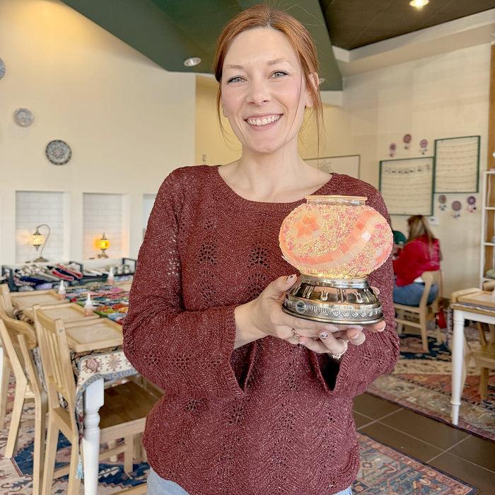 Guest smiling with her glowing mosaic lamp