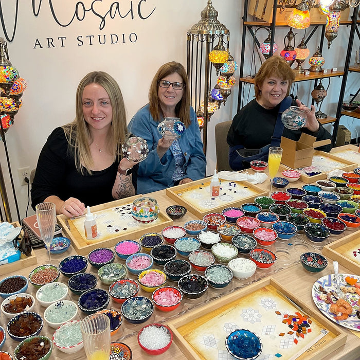 Friends showing their lamps around a table of coloured glass