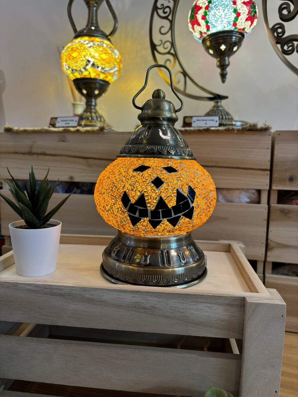 Orange jack-o-lantern mosaic lamp glowing on a table