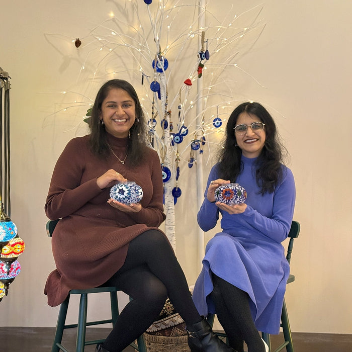 Mother and daughter smiling with their mosaic lamps