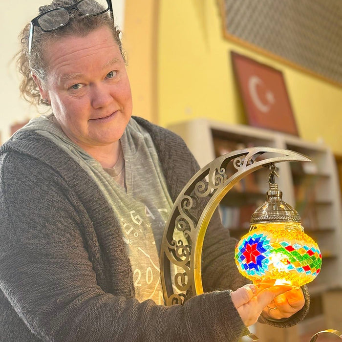 Guest with her finished mosaic moon lamp lit up