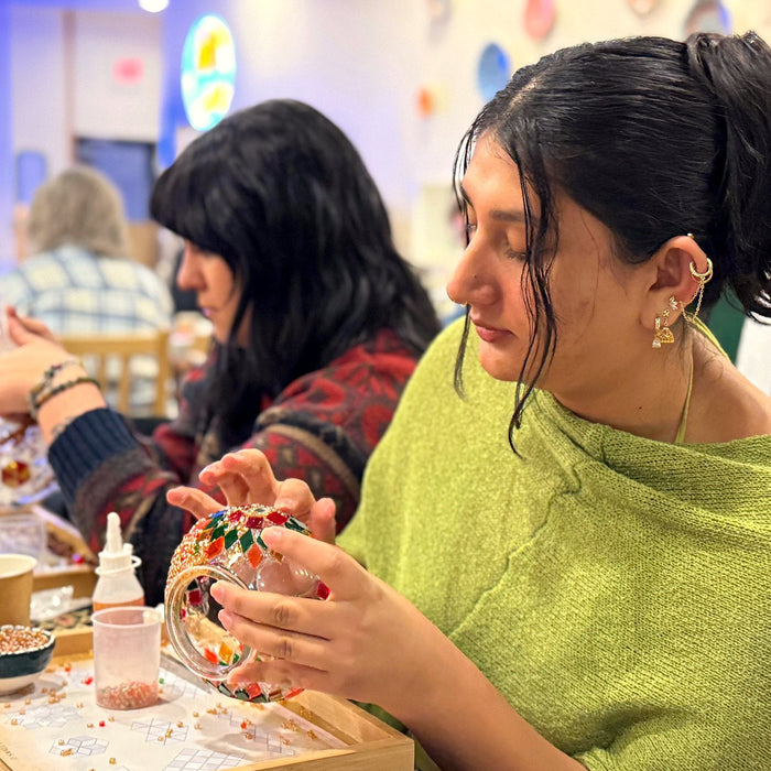 Guest concentrating as she places glass on her lamp