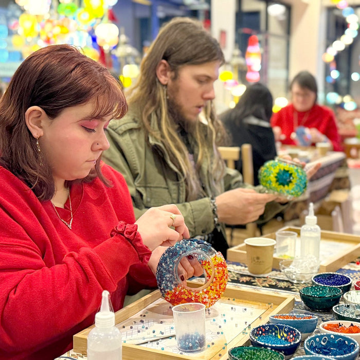 Young guests gluing glass onto their mosaic lamp globes