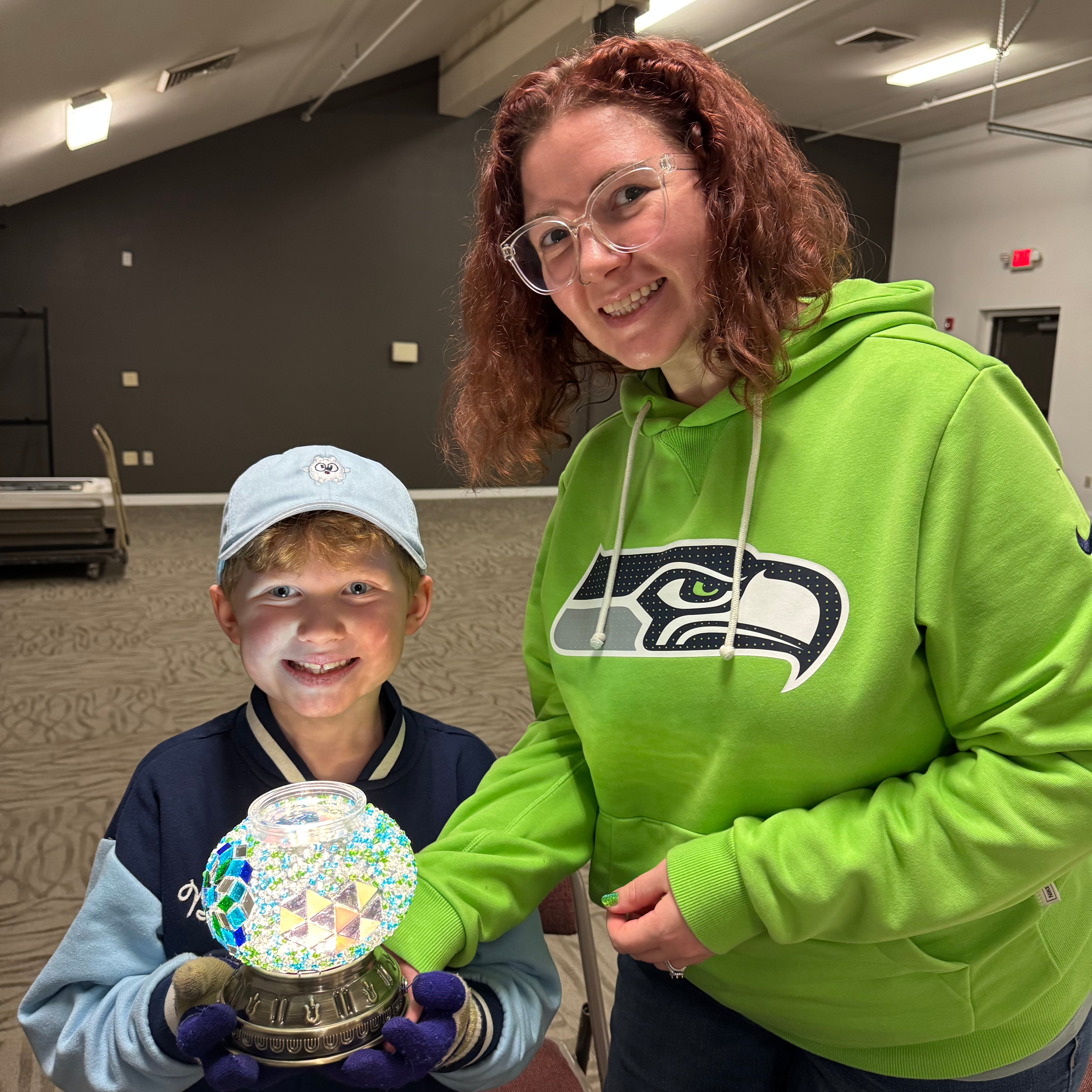 Camper holding a finished Turkish mosaic lamp at Mosaic Art Studio summer camp