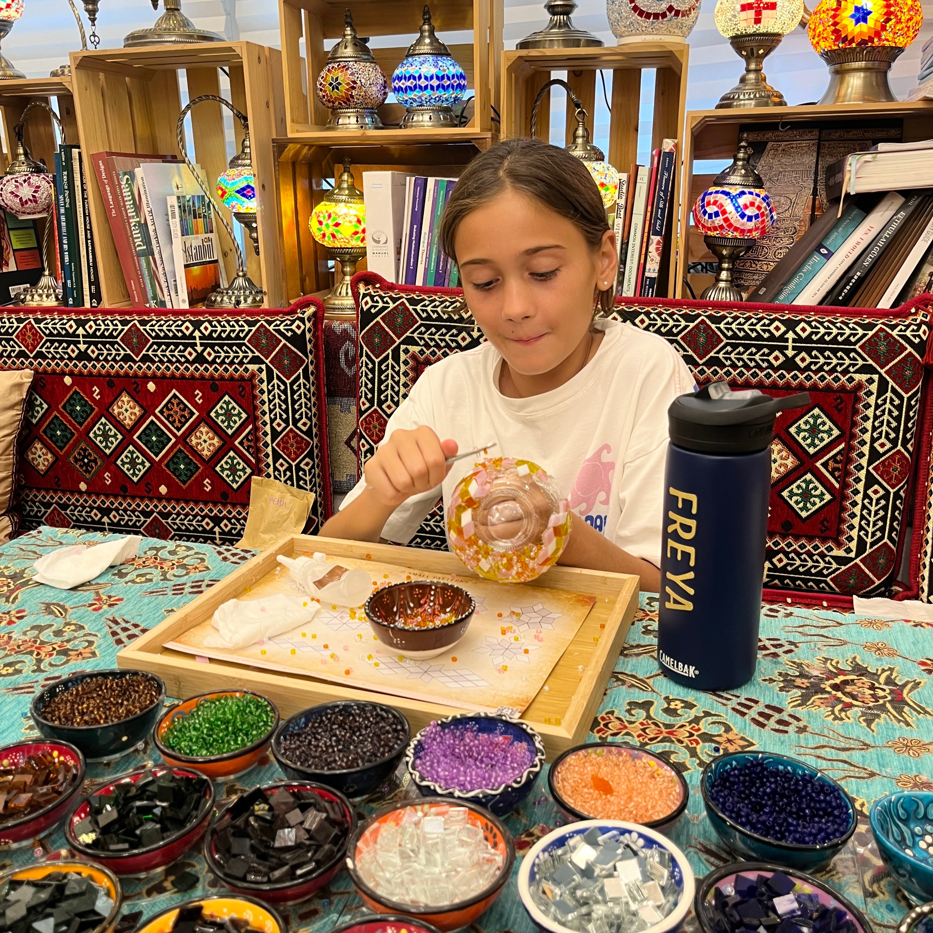 Camper placing colored glass tiles into a mosaic lamp at the Mosaic Art Studio summer camp Mosaic workshop