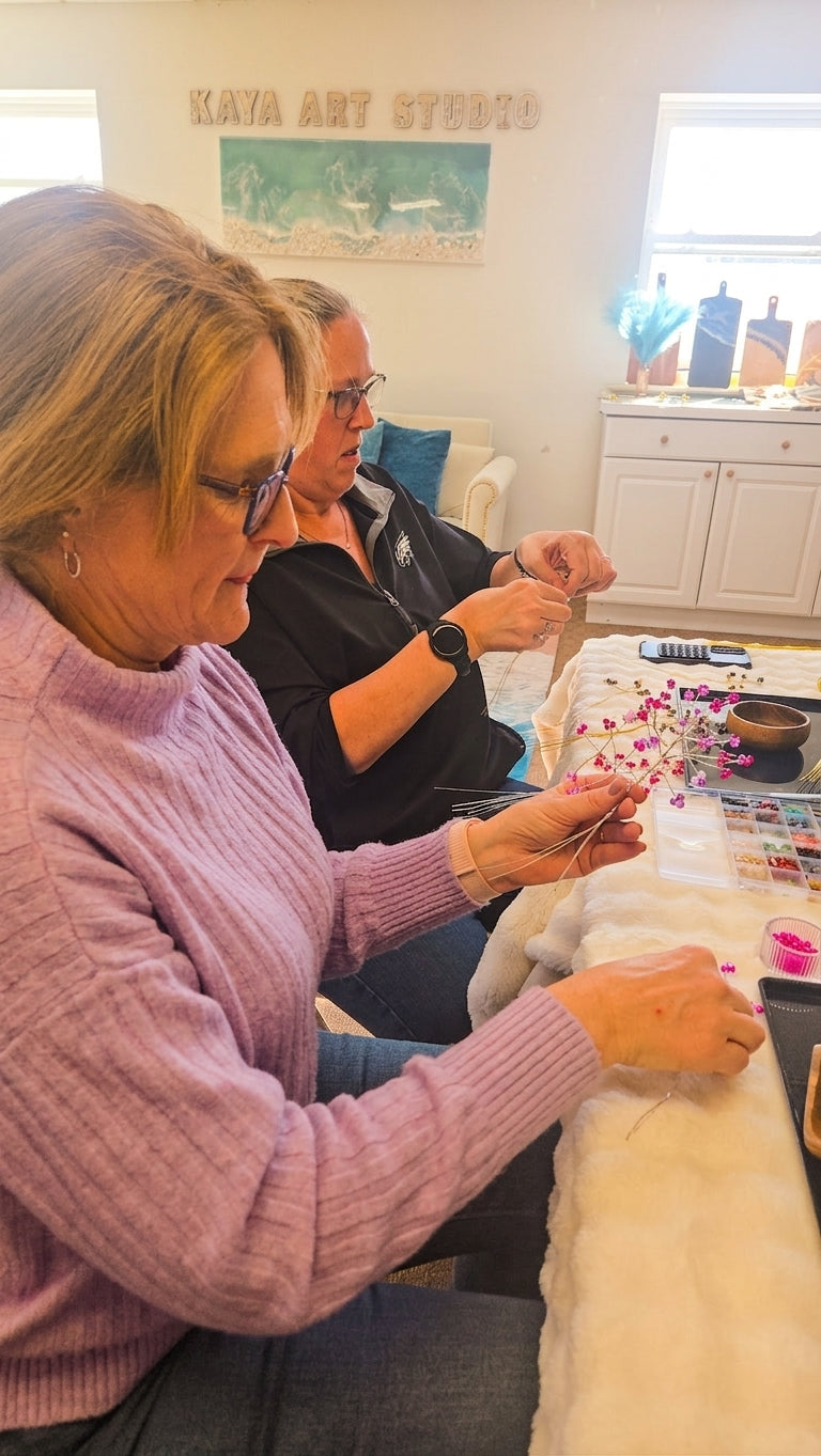Participant shaping pink beaded branches during the Wire Tree Art Workshop in King of Prussia, PA