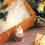 Christmas mosaic candle holder DIY kit with glue bottle, festive pine branches, and decorative lights