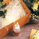 Christmas mosaic candle holder DIY kit with glue bottle, festive pine branches, and decorative lights