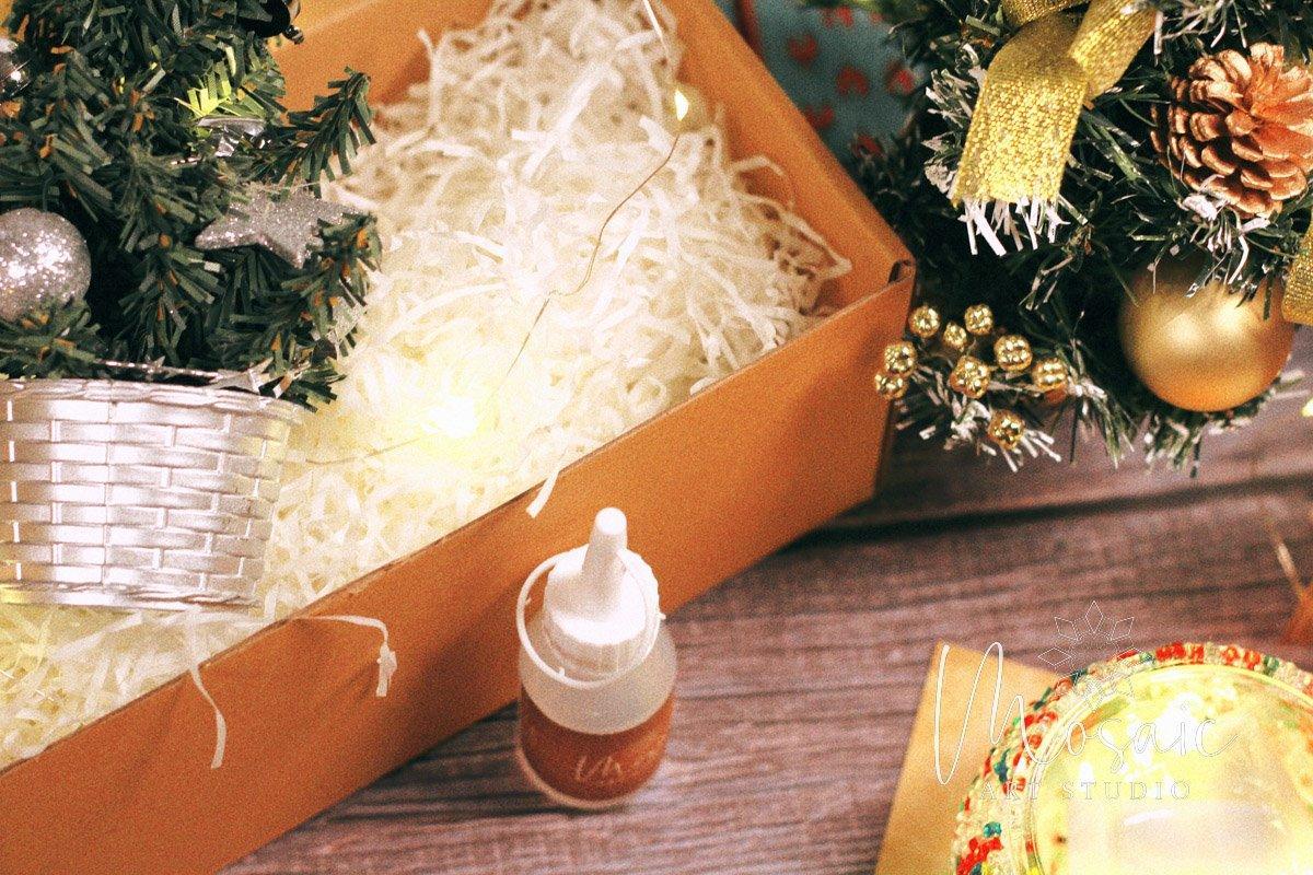 Christmas mosaic candle holder DIY kit with glue bottle, festive pine branches, and decorative lights